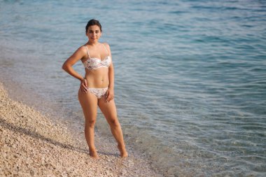 Bikiniplajda yürüyen çekici genç kadın