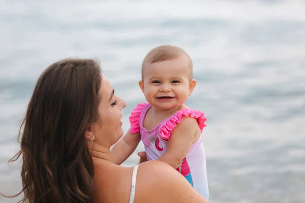 Máma políbila svou dcerku na pláž. Pozadí moře — Stock fotografie
