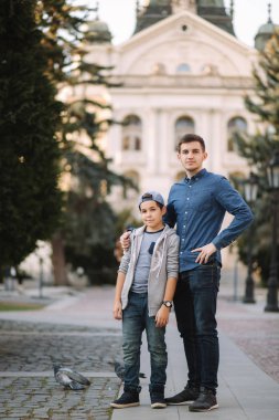 İki kardeş şehirde birlikte yürür. Mutlu aile dışarıda.