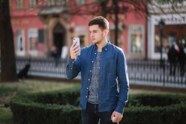 Genç adam şehrin merkezinde smartphome video vuruyor