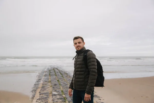 Promenade touristique masculine le long de la mer du Nord. Homme avec sac à dos debout sur la côte par temps pluvieux. Belle mer — Photo