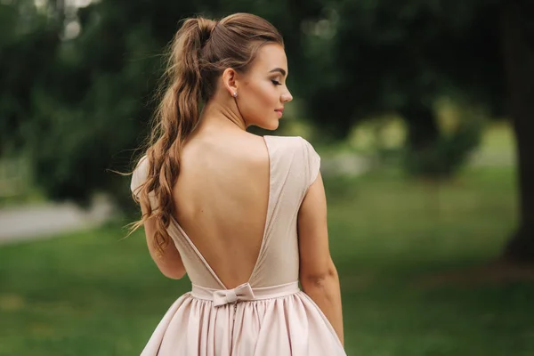 Posh glamoorus model sits on bench in evening dress — Stock Photo, Image