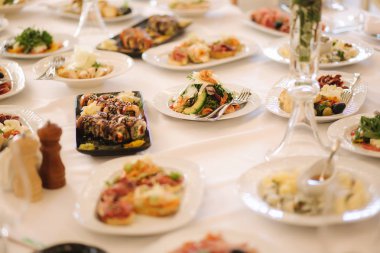 Karışık yiyeceklerle masa. Restoranda ziyafet, masa ayarı. Misafirler için farklı yemekler. Taze gıda