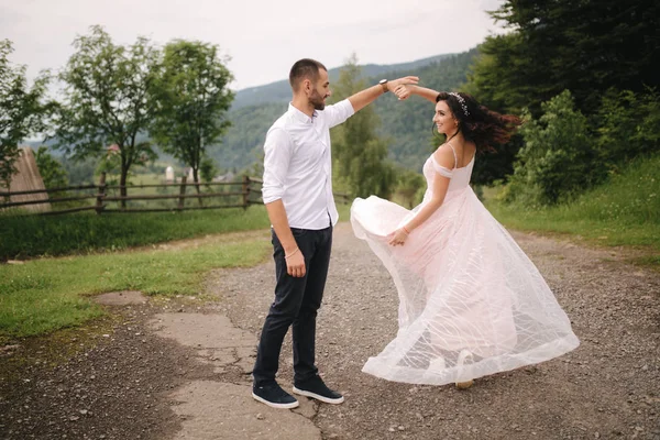Beautiful wedding couple in Carpathian mountains. Handsome man with attractive woman. Bride spin around