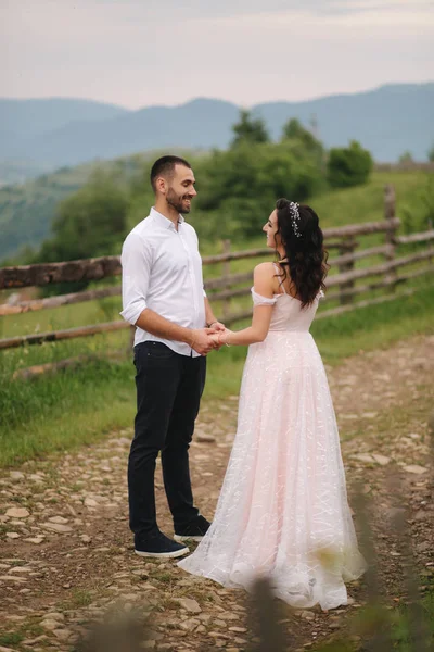 Knappe man leidt zijn bruid naar de prachtige Karpaten. Gelukkige bruiloft paar. Achteraanzicht — Stockfoto