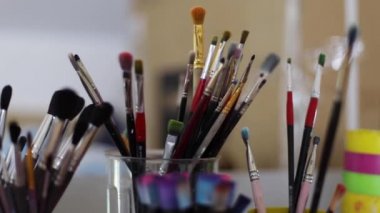 Kadın resim için fırça seçin. Sanat konsepti. Çizim stüdyosunda bir sürü fırça var. Fırça ile ellerinizi kapatın