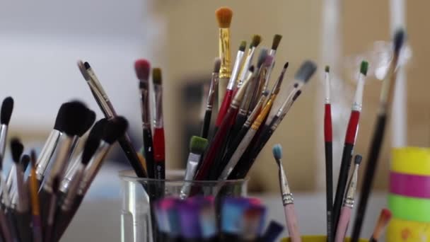 Woman choose brush for painting. Art concept. A lot of brushes in Drawing studio. Close up of hands with brush — Stock Video