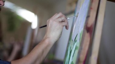 Sanatçı yağlı boya fırçası bir resim boyalar. Erkek sanatçının elinde fırça. Sanat konsepti. Resim resminin kapatılması