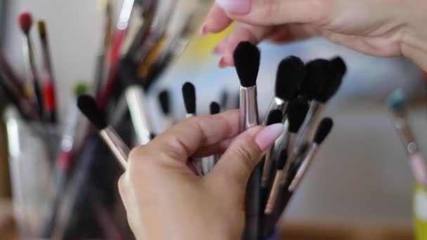 Kadın resim için fırça seçin. Sanat konsepti. Çizim stüdyosunda bir sürü fırça var. Fırça ile ellerinizi kapatın — Stok video