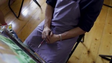 Sanatçı yağlı boya fırçası bir resim boyalar. Erkek sanatçının elinde fırça. Sanat konsepti. Resim resminin kapatılması
