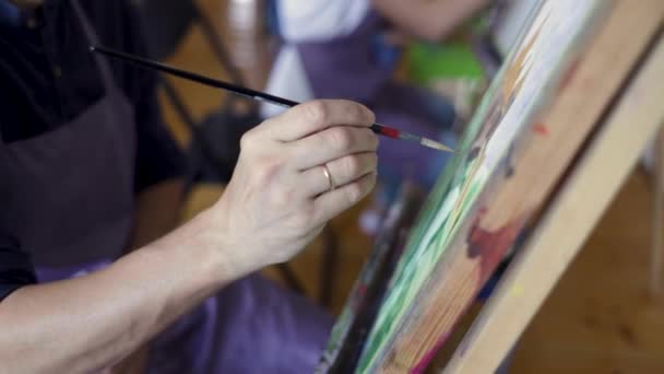 Artista pinta um quadro de pincel de tinta a óleo. Escova na mão do artista masculino. Conceito de arte. Close-up de quadro de pintura — Vídeo de Stock