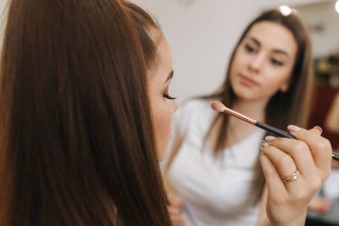 Makyaj sanatçısı göz farı, mükemmel akşam makyajı uygular. Mükemmel cilt ve çiller ile güzellik Redhead kız