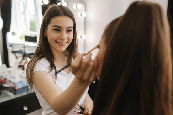 Maquiagem artista aplica sombra ocular, maquiagem noite perfeita. Menina ruiva beleza com pele perfeita e sardas — Fotografia de Stock