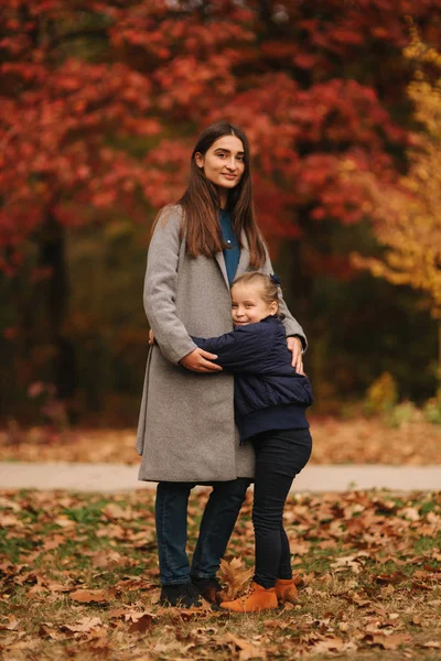 秋天的时候, 两个姐妹在公园里散步。童年。季节和人们的家庭。森林中快乐姐妹的肖像 — 图库照片