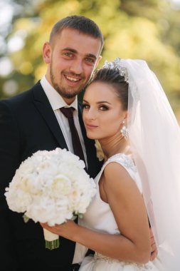 Parkta kocasıyla güzel bir gelin. Sarı ağacın arka planı. Mutlu çift