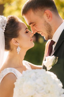 Parkta kocasıyla güzel bir gelin. Sarı ağacın arka planı. Mutlu çift. Portreyi clouse