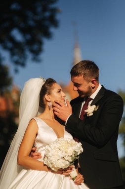 Damat ve gelin kalenin önünde duruyorlar. Kadın elinde beyaz çiçek buketi tutun