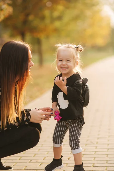 Mother and little daughter walking in autumn weather. Stylish little daughter and her beautiful mother. Happy childhood. Outdoors portrait of happy family. Have fun — Stock Photo, Image