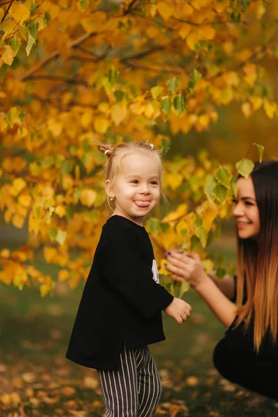 Mother and little daughter walking in autumn weather. Stylish little daughter and her beautiful mother. Happy childhood. Outdoors portrait of happy family. Have fun — Stock Photo, Image