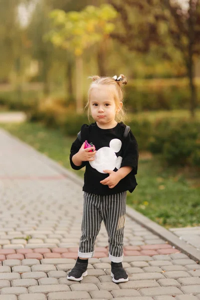 가을에 공원에서 걷는 행복한 어린 소녀. 노란색 배경에 아름다운 여성 아이 — 스톡 사진