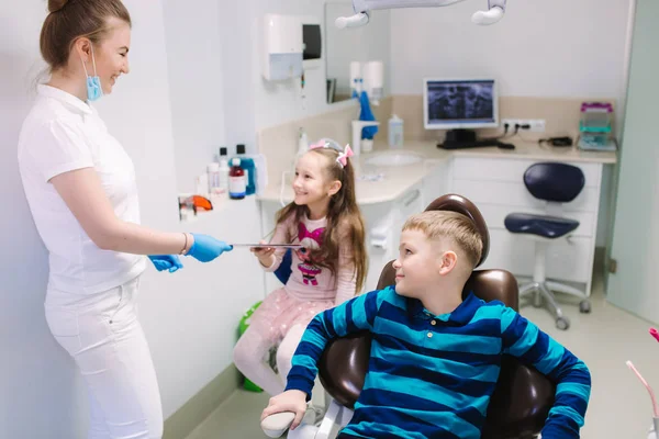 Dentist give a toy for little patient, happy children get a present