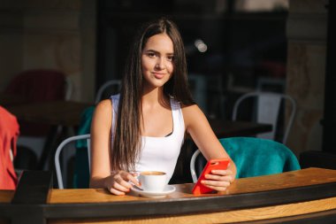 Kafede telefon kullanan çekici genç kadın. Güzel esmer kız sohbet