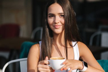 Kafede cappuccino içen bir kıza yaklaş. Güzel esmer