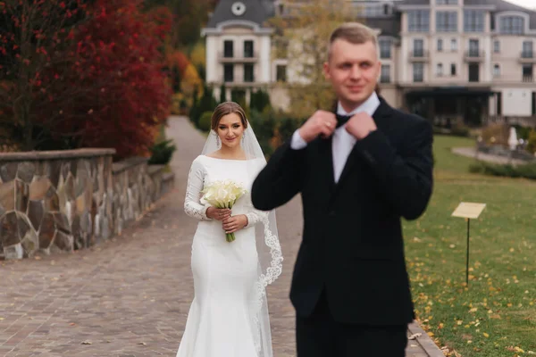 근사 한 부부가 결혼식 날 공원을 산책하는 모습. 가을 날씨에는 밖에서 행복 한 신혼 부부가 됩니다. 신부 앞에서 신랑 스테인드 — 스톡 사진
