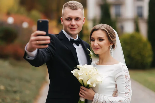 Gli sposi fanno un selfie sullo smartphone in autunno — Foto Stock