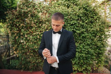 Yakışıklı damat, düğün ceketini giymişti. sonbahar havası