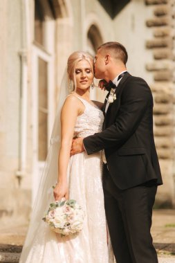 Damat ve gelin Merdivenlerde dur. Şık giysileriyle moda modeli. Beyaz uzun elbise ve şık takım elbise