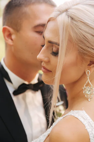 Fechar de noivo beijando noiva. Bela maquiagem e penteado. Retrato de casal encantador — Fotografia de Stock