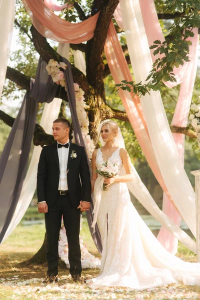 Po prostu małżeństwo świętować na koniec ceremonii ślubnej tle drzewa recorated — Zdjęcie stockowe