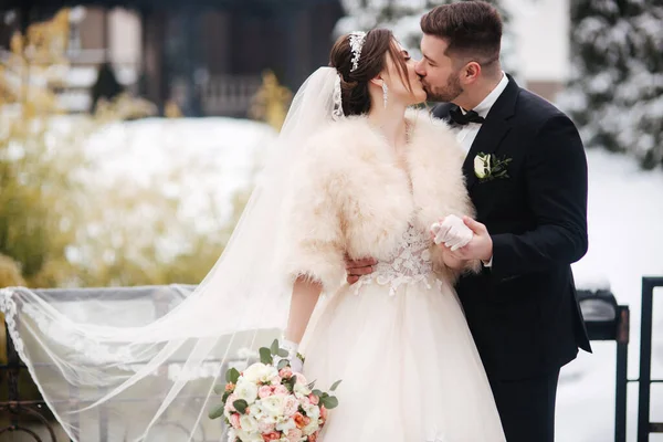 Frischvermählte im Wittershauser Park spazieren. Schöner Bräutigam und schöne Braut, umgeben von Schnee. Winterhochzeit — Stockfoto