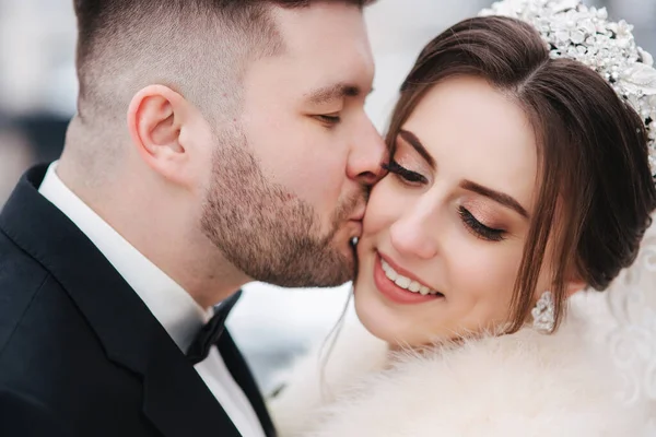 Wedding couple in winter time walking outside. Beautiful bride and handsome bearded groom