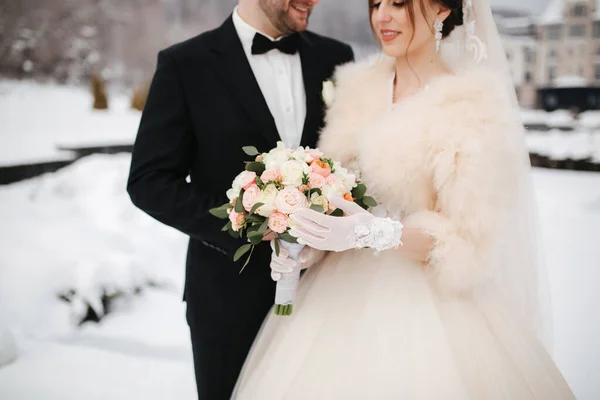 Frischvermählte im Wittershauser Park spazieren. Schöner Bräutigam und schöne Braut, umgeben von Schnee. Winterhochzeit — Stockfoto