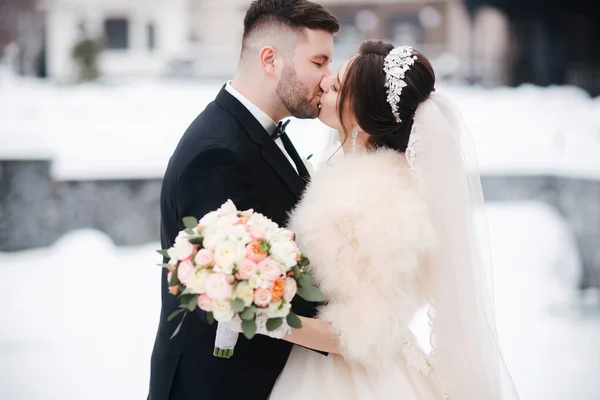 Hochzeitspaar im Winter zu Fuß nach draußen. Schöne Braut und schöner bärtiger Bräutigam — Stockfoto