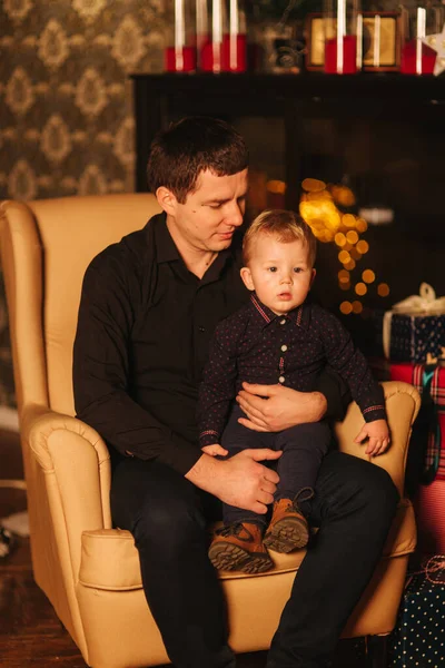 Bonito homem com filho sentado na poltrona em casa. Humor de Natal — Fotografia de Stock