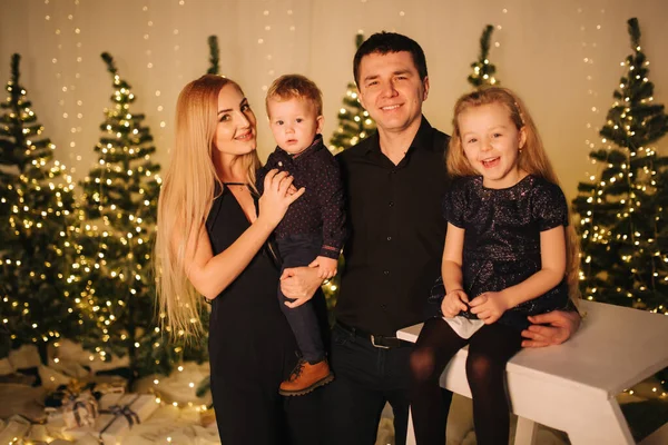 Різдвяна родина. Портрет батька, мами, дочки і сина, що сидить вдома біля ялинки. Щаслива сім'я. Різдвяний настрій — стокове фото