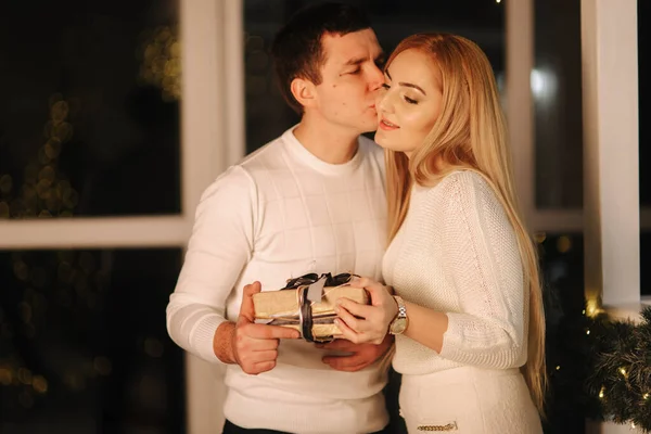 Esposo da regalo para su esposa, fondo de ventana. Mujer feliz toma regalo — Foto de Stock