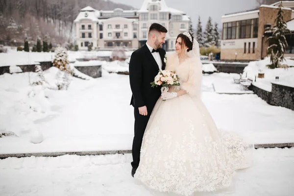 Gli sposi novelli di witer park se ne vanno in giro. Bello sposo e bella sposa circondata dalla neve. Matrimonio invernale — Foto Stock