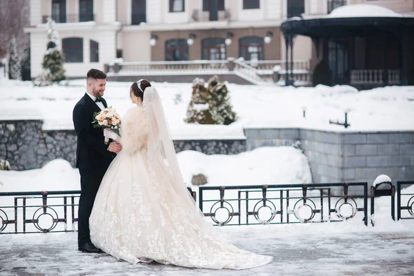 Matrimonio coppia in inverno a piedi fuori. Bella sposa e bello sposo barbuto — Foto Stock