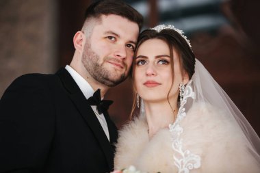 Damadın genç gelini balkonda duruyor. Kışın kürk mantolu gelin