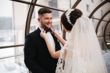 Damat ve gelin cam tünelde yürüyor. Mutlu yeni evliler, düğün günlerinde. Dışarıda kış var.