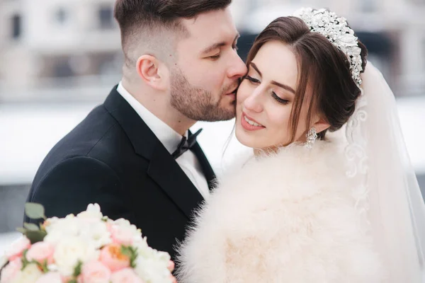 Matrimonio coppia in inverno a piedi fuori. Primo piano di bello barbuto sposo bacio bella sposa — Foto Stock