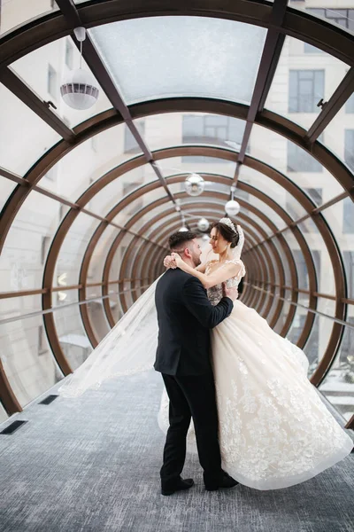 Bräutigam und Braut im Brillentunnel. Glückliches Brautpaar am Hochzeitstag. Draußen ist Winter — Stockfoto