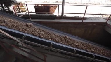 Çalışan ve kum taşıyan makineler. Endüstrideki taşıma bandı, seramik fabrika ekipmanları, taşıyıcıdaki kilin taşınması.