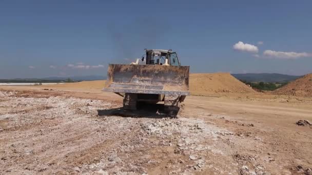 Gelber LKW auf großer Fabrik. Bagger fährt auf Steinbruch auf — Stockvideo