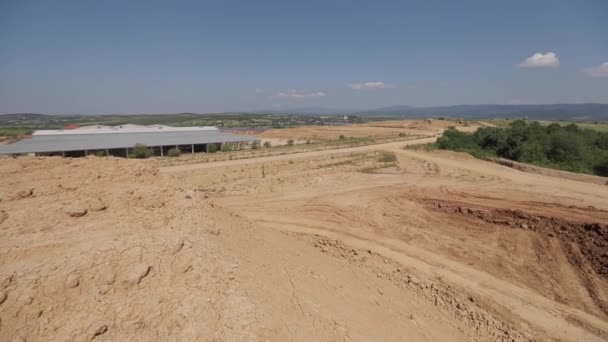 Gelber LKW auf großer Fabrik. Bagger fährt auf Steinbruch auf — Stockvideo