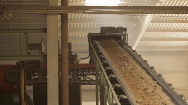 Çalışan ve kum taşıyan makineler. Endüstrideki taşıma bandı, seramik fabrika ekipmanları, taşıyıcıdaki kilin taşınması.